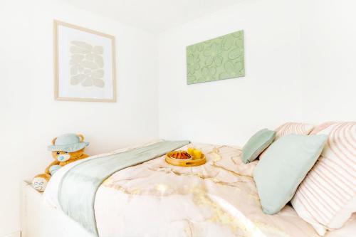 a white bed with a teddy bear sitting on it at Le Cocoon d'Alfortville - Aux portes de Paris in Alfortville