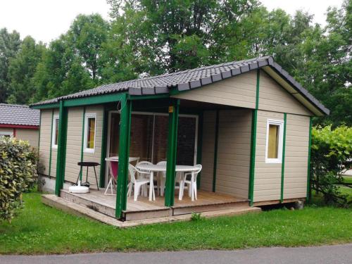 a green and white shed with a table on a deck at Chalet 4 pers avec Terrasse à Capvern - API-1-52-1745 in Capvern