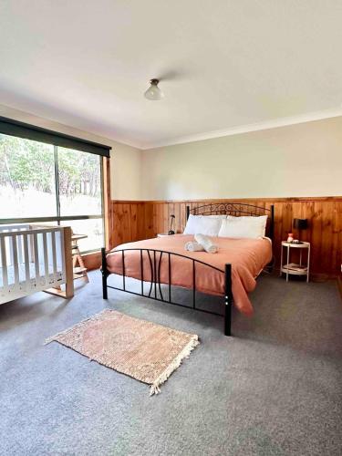 a bedroom with a bed and a large window at Halls Gap House in Halls Gap