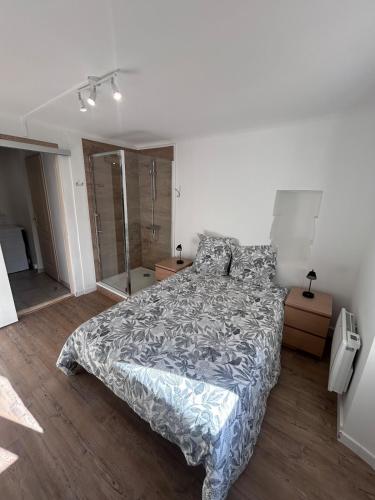 a bedroom with a bed with a comforter on it at Le cabanon in Puyloubier
