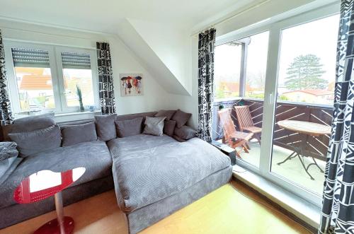a living room with a couch and a large window at Fewo Weitblick - helle Wohnung, 2 SZ, Wasserblick in Breege