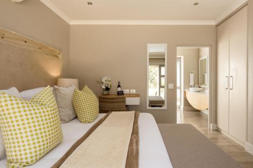 a bedroom with a bed with yellow and white pillows at Stellenbosch Luxury Apartments in Stellenbosch
