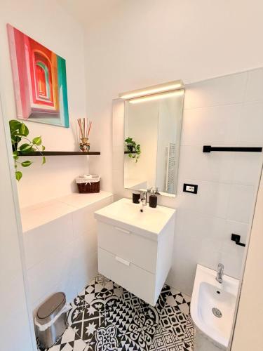 a white bathroom with a sink and a mirror at Duomo Rooms b&b in Lentini