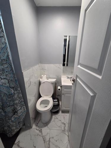 a white bathroom with a toilet and a sink at Queen Private room with private bathroom in Irvington