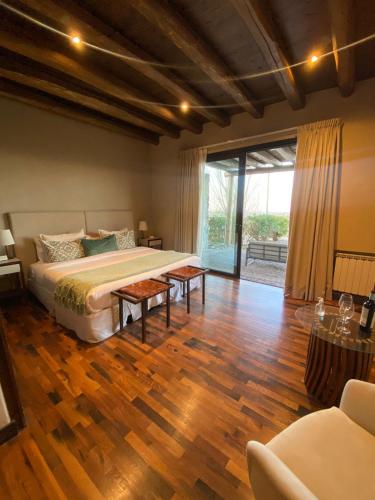 a bedroom with a large bed and a wooden floor at Casa de Huéspedes Bodega Gimenez Riili in Los Sauces