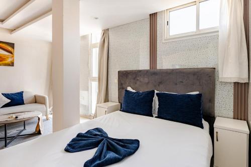 a bedroom with a large white bed with blue pillows at Moderne studio au coeur de rabat in Rabat