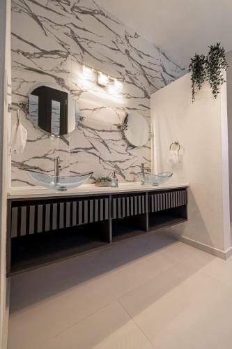 a bathroom with two sinks and a marble wall at Vista Serena in Salinas