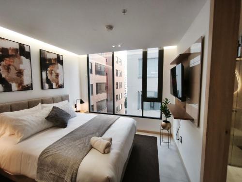a bedroom with a large bed and a large window at Adagio Quito Coliving Ecuador Residences in Quito
