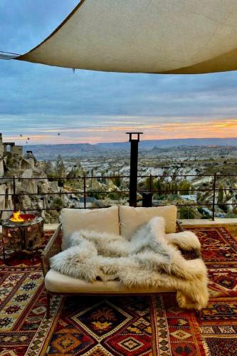 a white couch sitting on a balcony with a view at Very Peri Cappadocia - The Lifestyle Luxury Design Hotel in Uçhisar