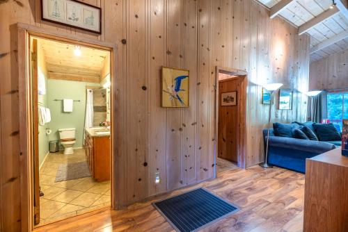 a living room with wooden walls and a blue couch at Aunt Ginnys River View in Monte Rio