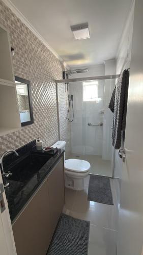 a bathroom with a toilet and a sink and a shower at Apartamento 3 quartos próximo à praia central de BC in Balneário Camboriú
