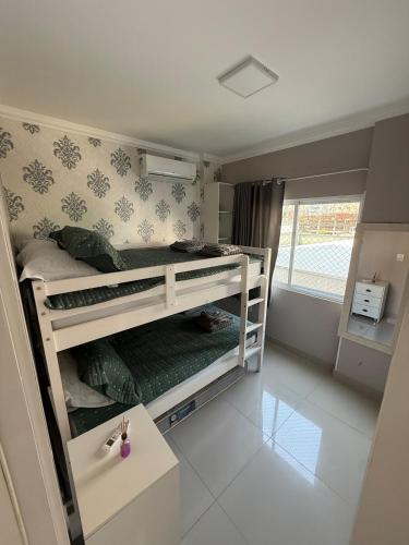 a small room with two bunk beds in it at Apartamento 3 quartos próximo à praia central de BC in Balneário Camboriú