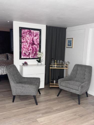 a living room with two chairs and a painting at Private Studio in an Edwardian Town Home in San Francisco