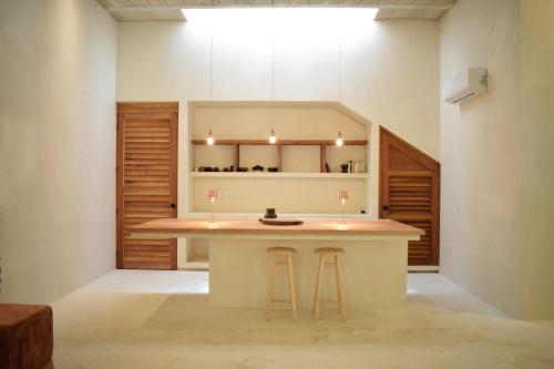 a kitchen with a counter and stools in a room at Casa Boutique Coco Calin in Sisal
