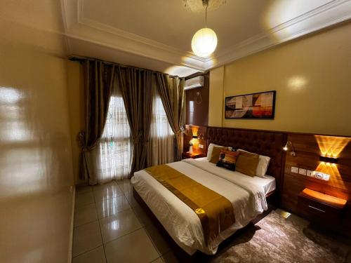a bedroom with a large bed and a window at Résidences hôtelières Micheline et Emile BASTOS in Yaoundé