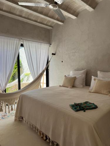 a bedroom with a hammock bed with a window at Casa Boutique Coco Calin in Sisal