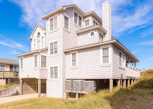 a large white house on top of a hill at Looking Glass - Nags Head MP 12, Oceanfront, Ocean View, Pool, Hot Tub, Pets OK, Flex Stays in Nags Head