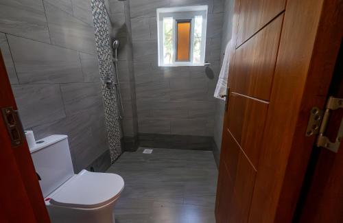 a small bathroom with a toilet and a window at Wakesho Apartment A in Malindi