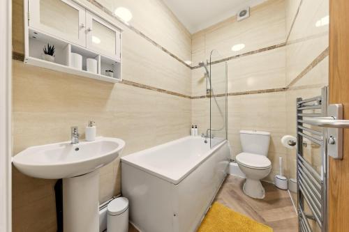 a white bathroom with a sink and a toilet at Stylish, Modern & Spacious 3 Bed Apartment in King's Cross - The York Suite in London