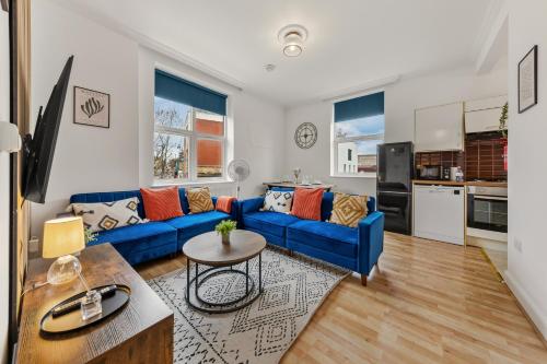 a living room with a blue couch and a table at Stylish, Modern & Spacious 3 Bed Apartment in King's Cross - The York Suite in London