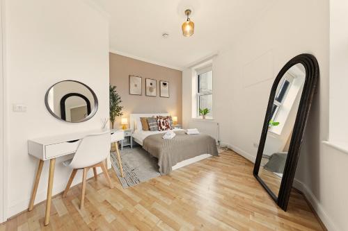 a bedroom with a bed and a desk and a mirror at Stylish, Modern & Spacious 3 Bed Apartment in King's Cross - The York Suite in London