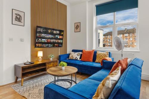 a living room with a blue couch and a table at Stylish, Modern & Spacious 3 Bed Apartment in King's Cross - The York Suite in London