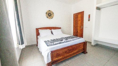 a bed in a bedroom with a clock on the wall at Wakesho Apartment A in Malindi