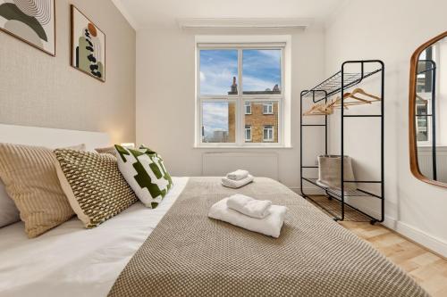 a bedroom with a bed and a window at Stylish, Modern & Spacious 3 Bed Apartment in King's Cross - The York Suite in London