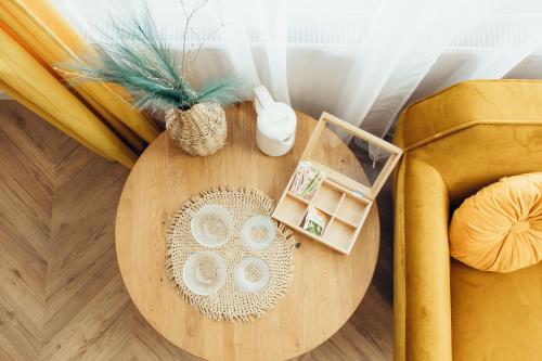 a wooden table with two plates on it next to a couch at IUGAs RESIDENCE in Sighetu Marmaţiei
