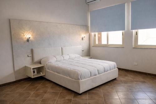a bedroom with a large white bed and a window at V&G palma di montechiaro in Palma di Montechiaro