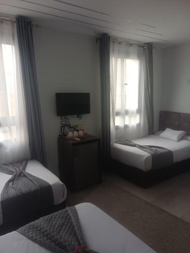 a hotel room with two beds and a television at Capital Hotel in Downtown in Cairo