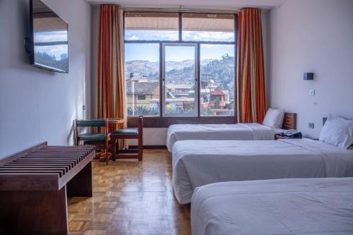 a hotel room with two beds and a window at Real Hotel Huascaran in Huaraz