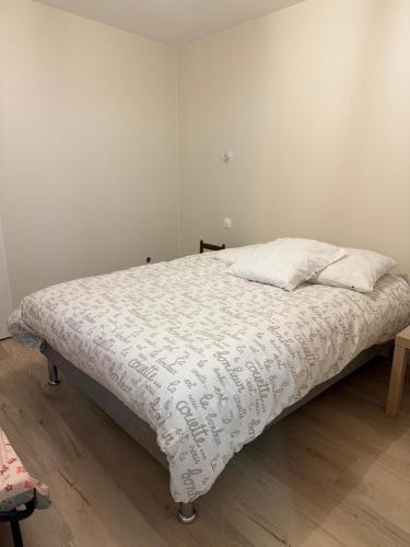Maison 65m2 في Écommoy: غرفة نوم بها سرير مغطى بغطاء أبيض