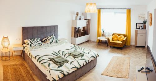 a bedroom with a large bed and a chair at IUGAs RESIDENCE in Sighetu Marmaţiei