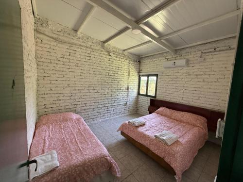 a room with two beds and a brick wall at Viñedos del Este in San Juan