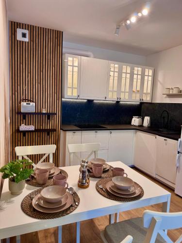 a kitchen with a table with dishes on it at Apartament Perła Łagowa in Łagów