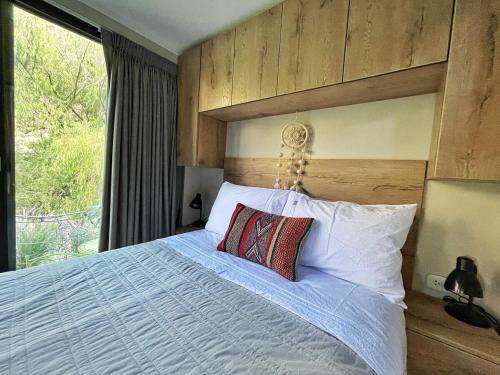 a bedroom with a large bed with a large window at Tiny Mountain River in Urubamba