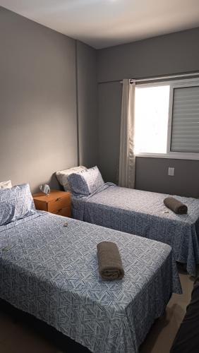 a room with two beds and a window at Lar dos Santoprete I in Bertioga