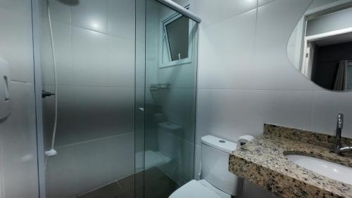 a bathroom with a shower and a toilet and a sink at Lar dos Santoprete I in Bertioga