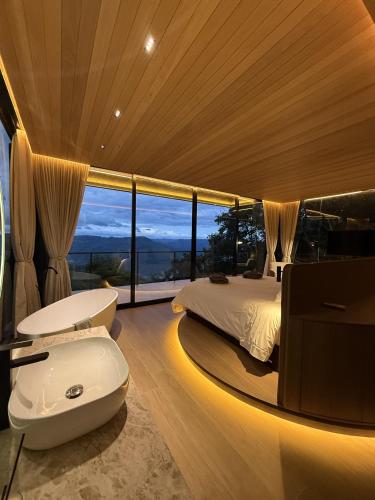 a bedroom with a large bed and a large window at Casas na montanha - Villa Montegrappa in Caxias do Sul