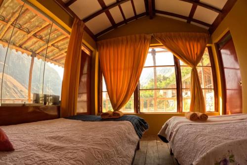 a bedroom with two beds and a large window at La Casa de Roy in Cosnihua