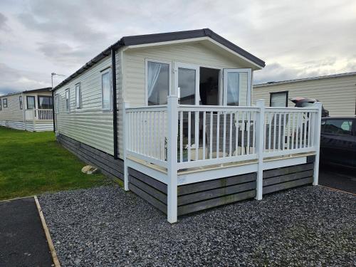 a mobile home with a porch and a white railing at Rendezvous at Ocean Edge in Heysham