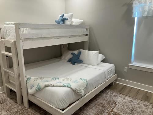 a bunk bed with a teddy bear sitting on top at Seaglass Cottage in Rockport