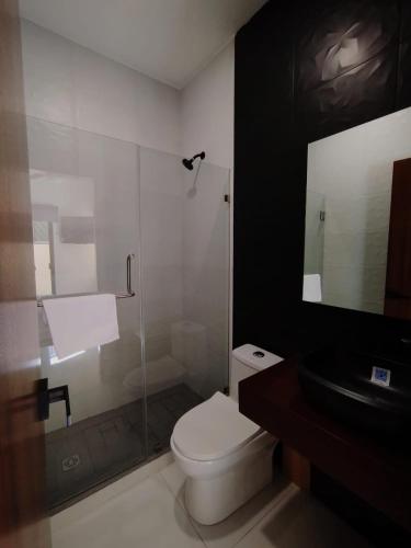 a bathroom with a toilet and a glass shower at Día y noche in Guadalajara