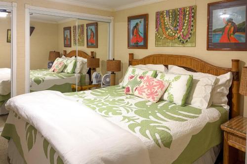 a bedroom with a bed with green and white pillows at Oceanfront Condo: Stunning Sunrise & Ocean Views in Hauula
