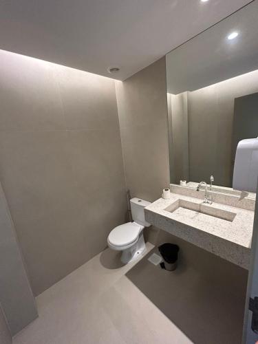 a bathroom with a toilet and a sink and a mirror at Studio Gardenia Mobiliado - Batista Campos in Belém