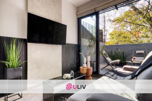 a living room with a tv on a wall at ULIV Park Polanco in Mexico City