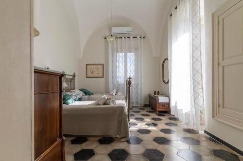 ein Schlafzimmer mit einem Bett und ein Zimmer mit einem Fenster in der Unterkunft Villa Morea-Relax in piscina in Putignano