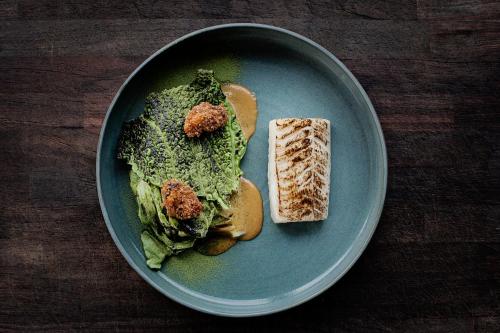 a blue plate with a sandwich and a piece of bread at Katrinelund Gästgiveri & Sjökrog in Stora Mellösa