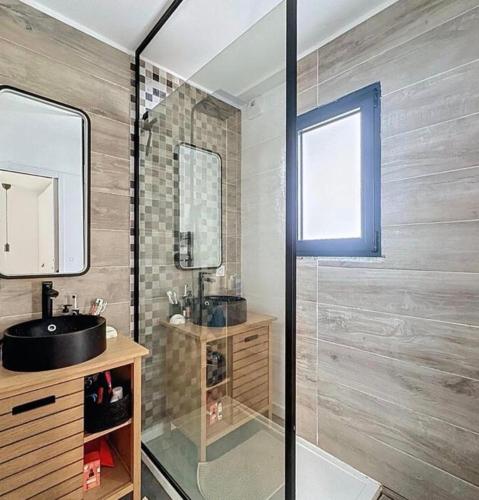 a bathroom with a sink and a glass shower at La parenthèse basque in BIQ